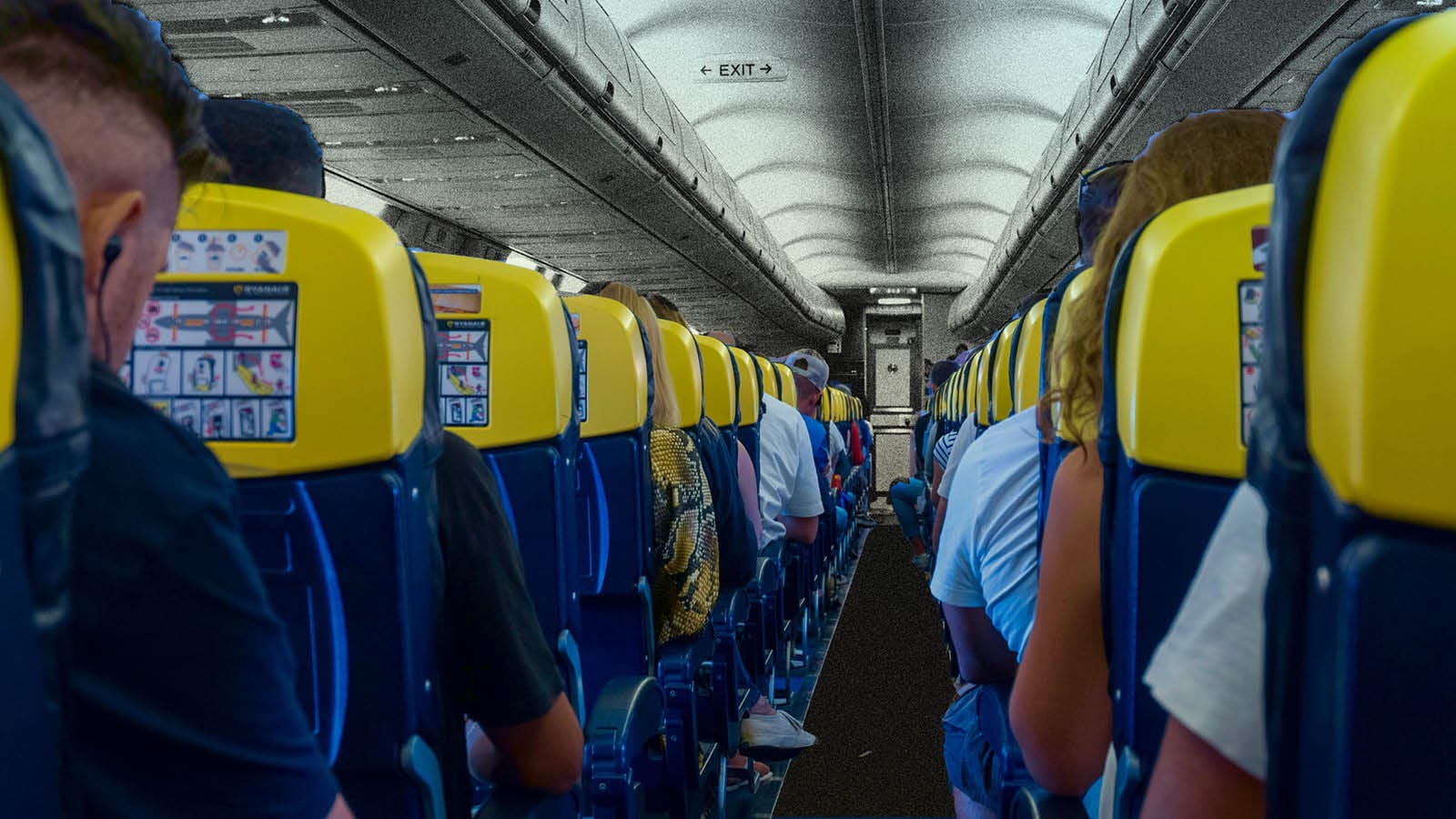 A photo looking down the aisle of an airplane during a packed flight.