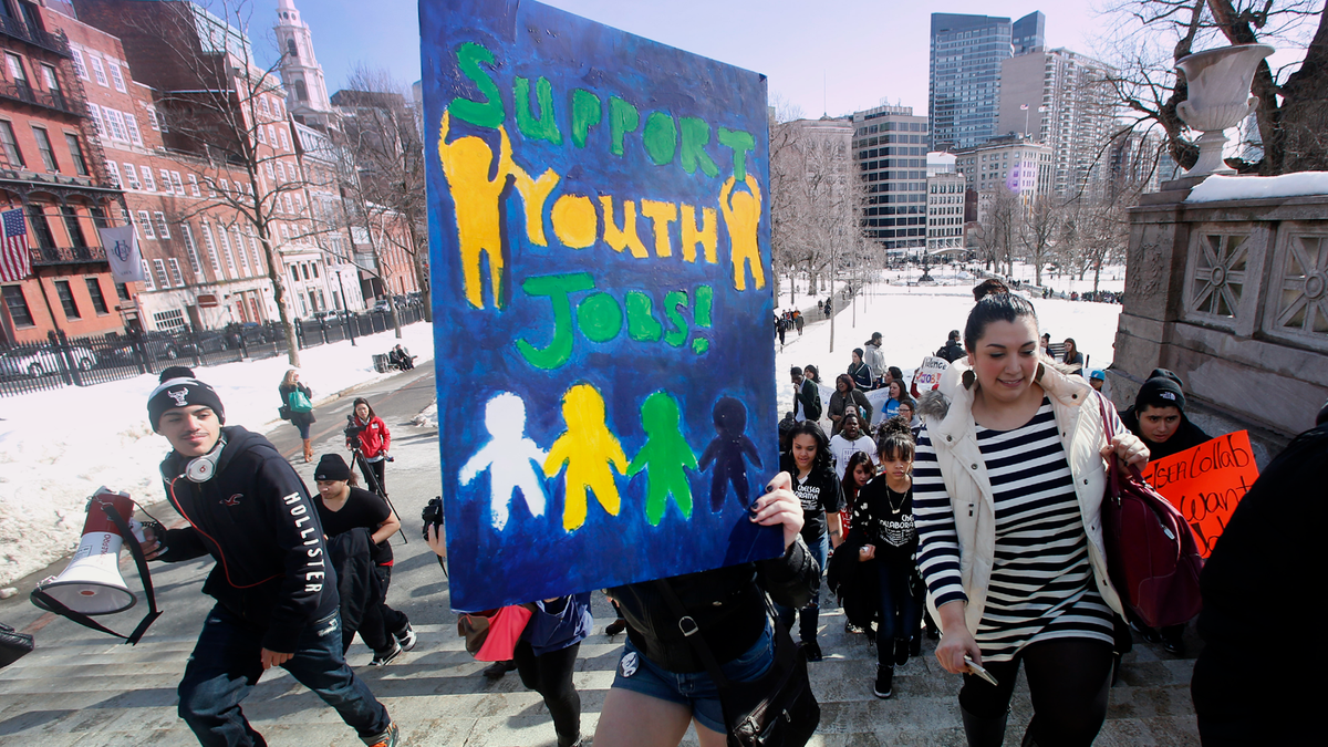 Young people from across Massachusetts carry signs and chant while they march in Boston.