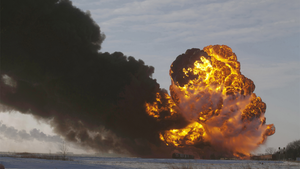 A fireball goes up at the site of an oil train derailment.